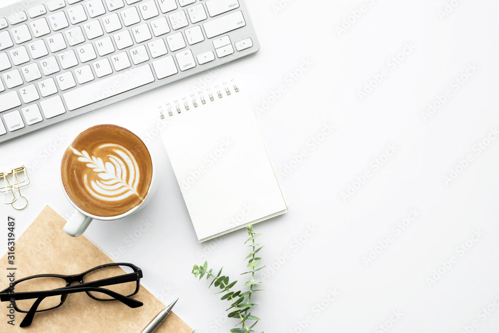 White office desk table with small blank notebook, cup of latte coffee and office supplies. Top view with copy space, flat lay. - obrazy, fototapety, plakaty 