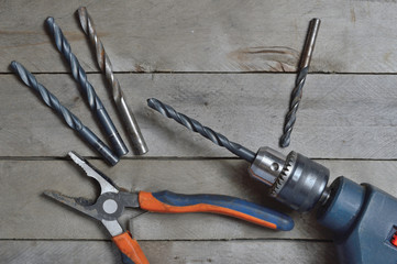 electric drill and tools for working on a wooden surface. view from the top.