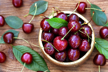 Wall Mural - Sweet fresh summer cherries on berries and leaves background, selective focus