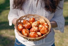 Traditional Easter Eggs Dyed With Natural Onion Peels And Leaves Or Flowers. Young Woman Holding Basket.