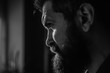 © Tverdokhlib - Handsome and confident. Outdoor portrait of young man with beard. Portrait of a bearded man with an intense look standing in a dark room against a black background.