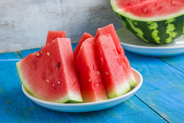 fresh juicy sliced watermelon on plate on blue wooden table summer fruit