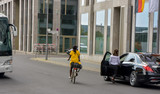 Fototapeta Londyn - woman with yellow shirt riding a bicycle in the streets of berlin