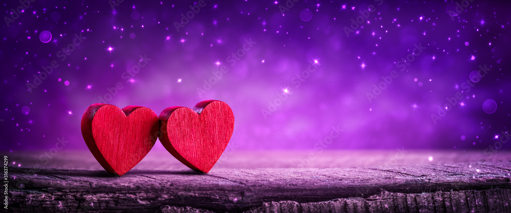 Two Wooden Hearts On Rustic Table With Sparkling Purple Background - Valentine's Day Concept - obrazy, fototapety, plakaty 