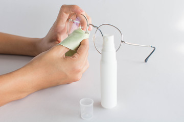 girl hand cleaning glasses lens with white background, cleaning glasses concept.