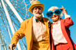 © Yakobchuk Olena - Happy cheerful elderly couple posing in colorful costumes