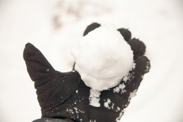  real snowballs with their hands clasped from the fresh snow in winter on the street