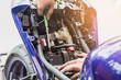 motorcycle mechanic replaces a battery. (maintenance) selective focus