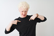 © Krakenimages.com - Young albino blond man wearing black t-shirt standing over isolated white background looking confident with smile on face, pointing oneself with fingers proud and happy.