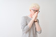 © Krakenimages.com - Young albino blond man wearing striped t-shirt and glasses over isolated white background smelling something stinky and disgusting, intolerable smell, holding breath with fingers on nose. Bad smells