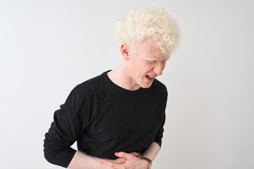 Wall Mural - Young albino blond man wearing black t-shirt standing over isolated white background with hand on stomach because indigestion, painful illness feeling unwell. Ache concept.