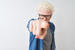 © Krakenimages.com - Young albino blond man wearing denim shirt and glasses over isolated white background pointing displeased and frustrated to the camera, angry and furious with you