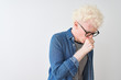 © Krakenimages.com - Young albino blond man wearing denim shirt and glasses over isolated white background feeling unwell and coughing as symptom for cold or bronchitis. Healthcare concept.