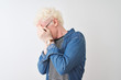 © Krakenimages.com - Young albino blond man wearing denim shirt and glasses over isolated white background with sad expression covering face with hands while crying. Depression concept.