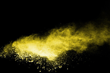 Yellow powder explosion on black background.