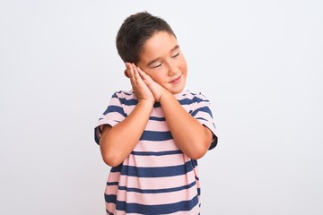 Canvas Print - Beautiful kid boy wearing casual striped t-shirt standing over isolated white background sleeping tired dreaming and posing with hands together while smiling with closed eyes.