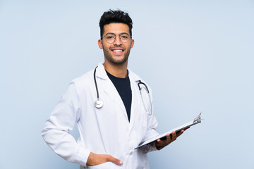 Wall Mural - Young doctor man over isolated blue wall
