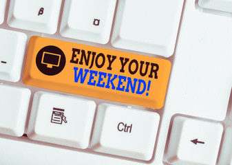 Writing note showing Enjoy Your Weekend. Business concept for wishing someone that something nice will happen at holiday White pc keyboard with note paper above the white background