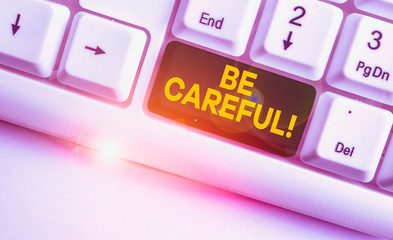 Conceptual hand writing showing Be Careful. Concept meaning making sure of avoiding potential danger mishap or harm White pc keyboard with note paper above the white background