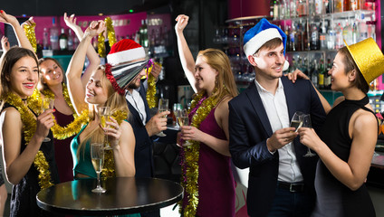 Portrait of dancing females and males in caps and garlands