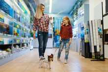 Mother with daughter walking in pet store