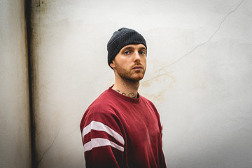 portrait of young rapper posing in front of a white wall