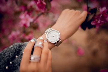 Wall Mural - Beautiful watch on woman hand in flowers