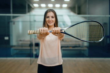 Wall Mural - Female player shows squash racket on court