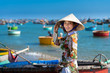 Vietnamese lady with Ao Dai Vietnam traditional dress and conical hat wait at the harbor, Fishing Harbour Mui Ne Vietnam