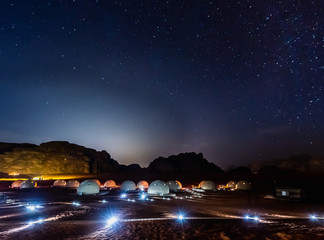 stars above martian dome tents in wadi rum desert, jordan.