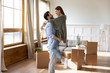 © fizkes - Smiling young couple celebrate relocation at home