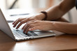 © fizkes - Close up female hands typing on keyboard, using laptop