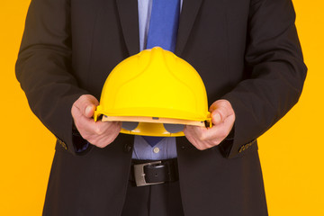 manager showing helmet on yellow background