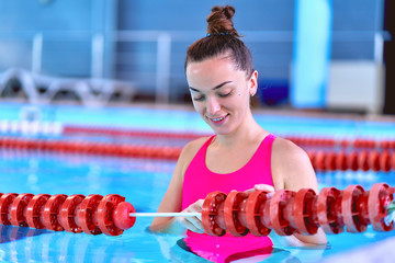 Young swimmer female in swimsuit during relaxing in swimming pool in leisure centre, healthy lifestyle