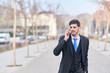 © Enadan - elegant young businessman talking on his cell phone in a clean, unfocused outdoor background