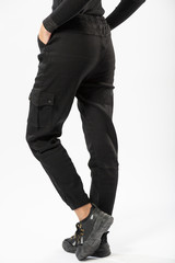 girl in black military trousers and black sports sneakers on a white background