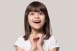 © fizkes - Cheerful excited little girl showing heart love gesture.