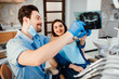 © Тарас Нагирняк - Dentistry and healthcare concept, male dentist showing teeth x-ray to female patient at dental white clinic room.
