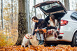 © Тарас Нагирняк - Young couple have a picnic with their dog near automobile in the autumn forest.