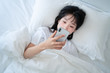© xxxstudio - asian young woman play cellphone on the bed