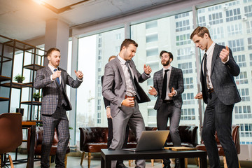 dancing happy business men after meeting in office, enjoy work together, celebrating at work. panoramic window in the background