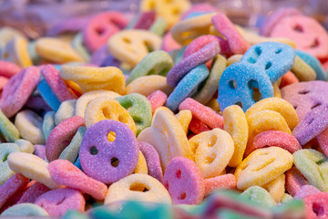 blue pink yellow green and purple colored sugar candies, close up