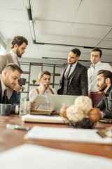 serious confident business people coworking in office, using laptop. men in tuxedo in formal wear look at screen of laptop and think about deadlines