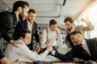 © alfa27 - business leaders playing in office after work, wearing formal clothes. active enthusiastic business crew gathered to support playing men