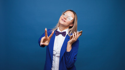 Wall Mural - Happy smiling young woman in blue on blue background. Friendly business portrait