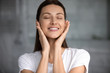 Head shot satisfied smiling woman with perfect skin touching face