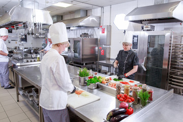 Wall Mural - cook preparing dinner in a restaurant kitchen.