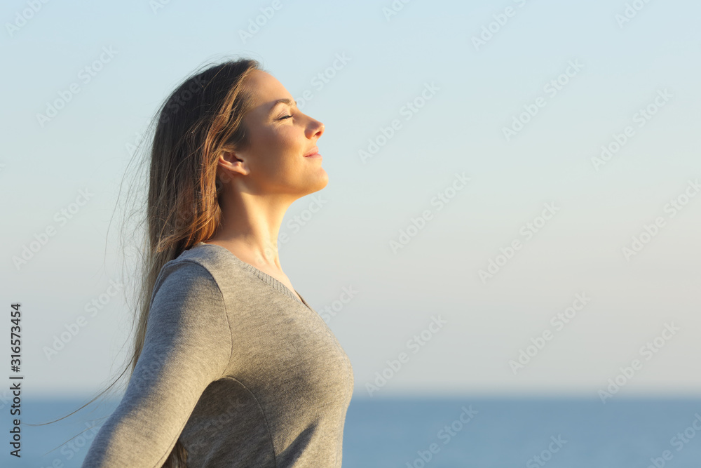 Obraz Woman breaths fresh air on the beach fototapeta, plakat