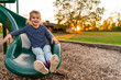 © Sarah Rypma - Young girl on a park playground slide at sunset