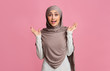 © Prostock-studio - Surprised muslim girl in hijab reising hands in amazement